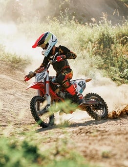 dziecko jeździ na torze motocrossem