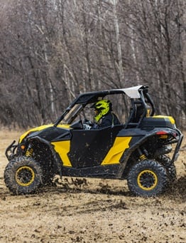 Żółte buggy z kierowcą w kasku podczas off roadu