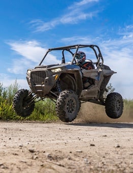 Buggy z kierowcą podskakujące nad ziemią podczas jazdy