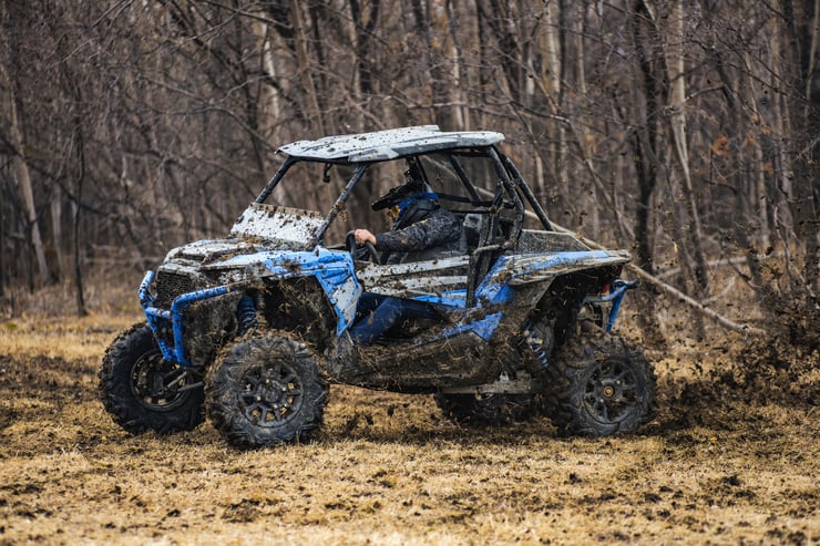 Niebieskie buggy całe w błocie podczas off roadu