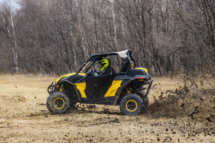 Żółte buggy z kierowcą w kasku podczas off roadu 