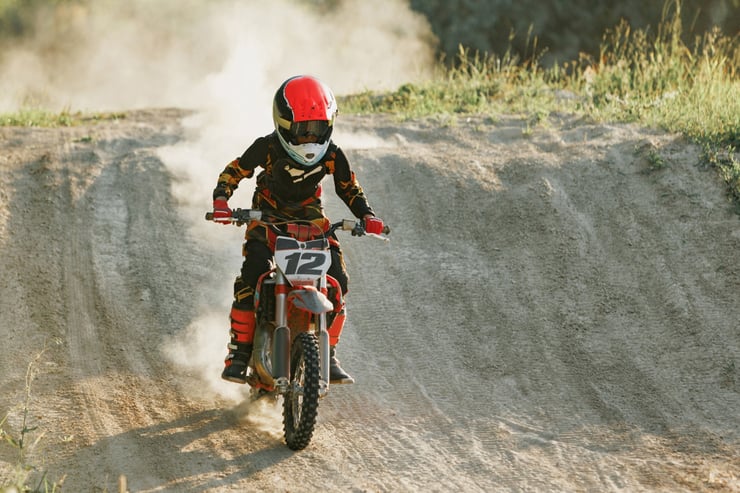 chłopiec zjeżdża z górki motocrossem