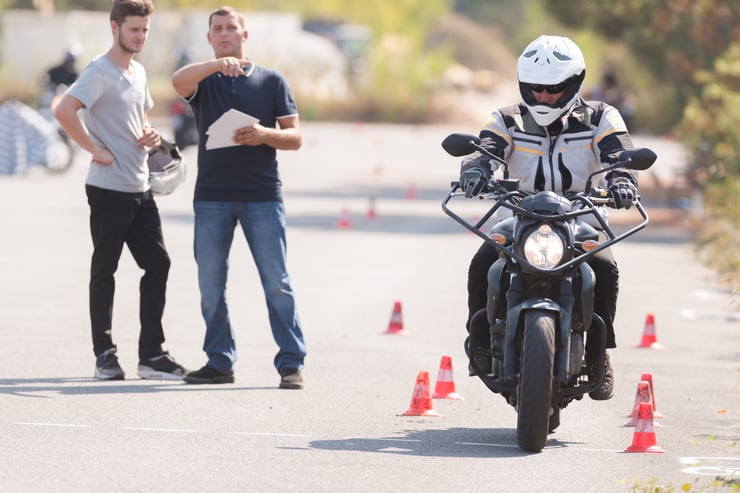 mężczyzna jadący motocyklem obok instruktorów