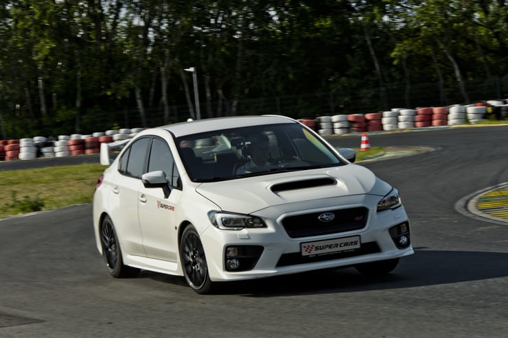 subaru w białym kolorze na zakręcie