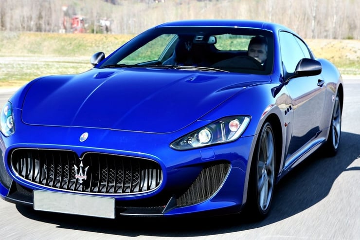Niebieskie maserati granturismo pędzące po torze wyścigowym