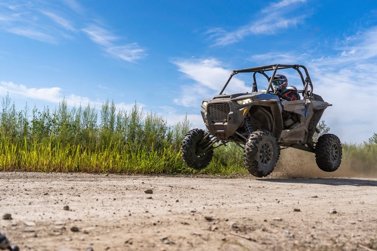 Buggy z kierowcą podskakujące nad ziemią podczas jazdy